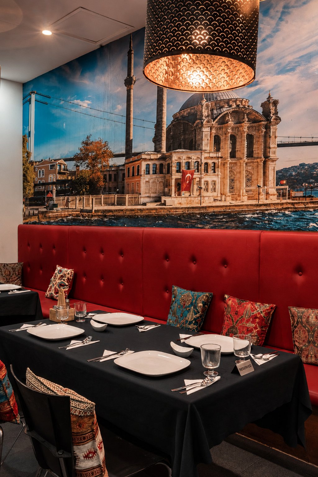 Dining table set beneath the Istanbul mural and woven pendant lights at Reyhan in Weston ACT